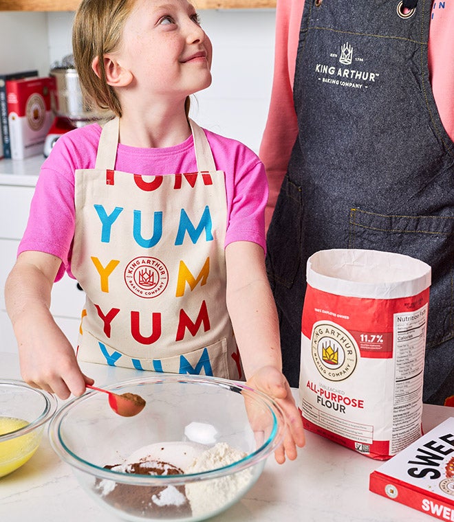 A young girl baking with her father