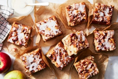 Slices of apple fritter cake on a sheet of parchment 