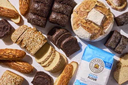 group of different breads surrounded by bread flour bag