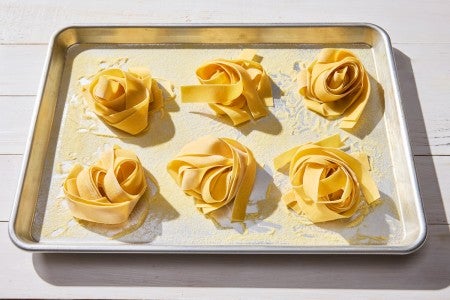 Nests of fresh pasta on a sheet pan