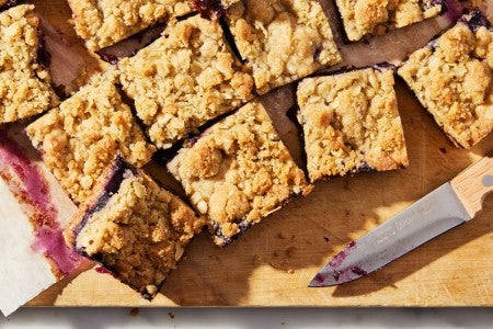 Sliced fruit bars on a cutting board next to a knife