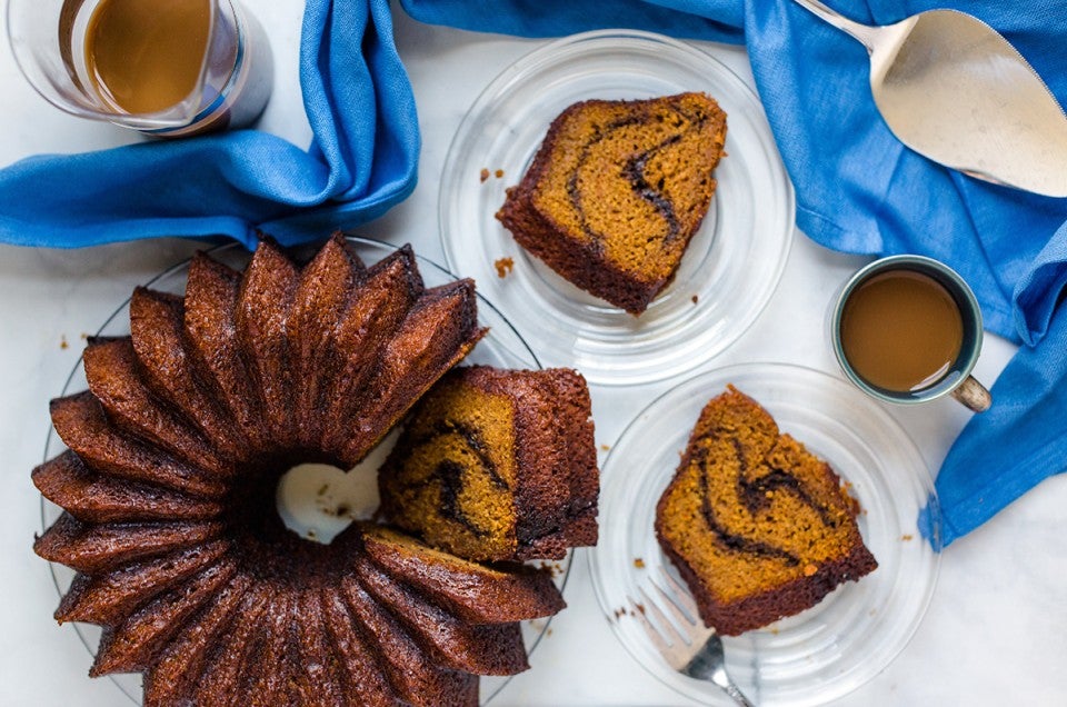 Pumpkin Espresso Bundt Cake with a few slices on plates next to a coffee