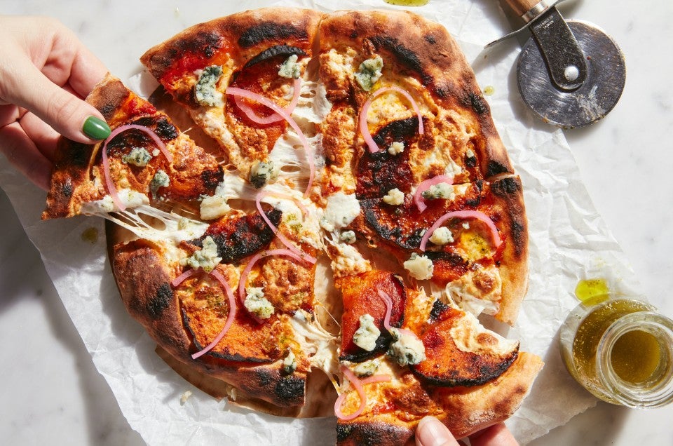 Hands pulling slices of baked No-Knead Artisan Pizza