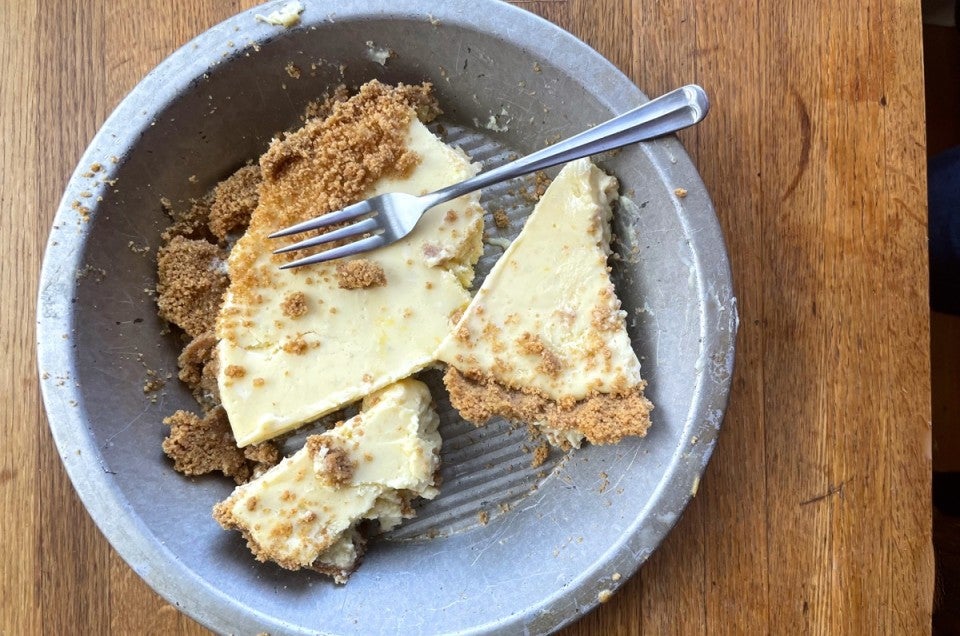 Cheesecake in a pie pan, crust separated from filling and broken into chunks