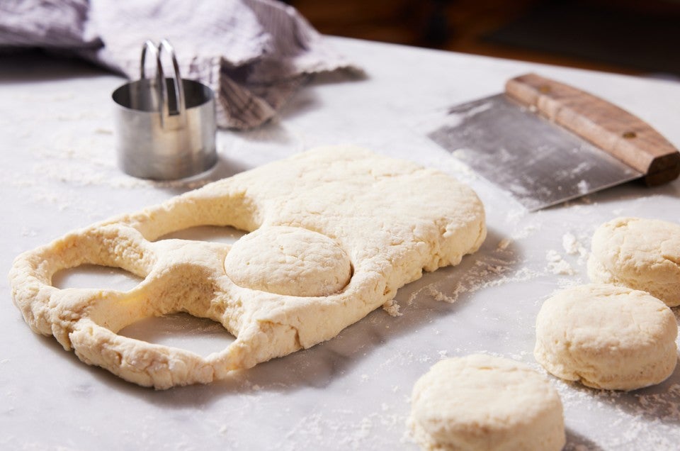 Biscuit dough being stamped out with biscuit cutter