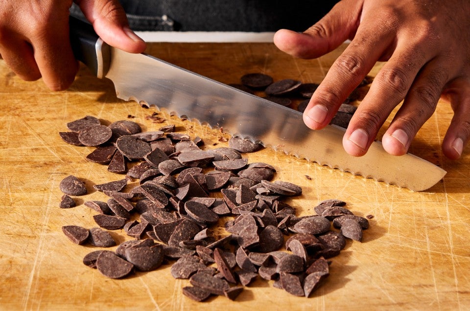 Baker chopping chocolate with serrated knife