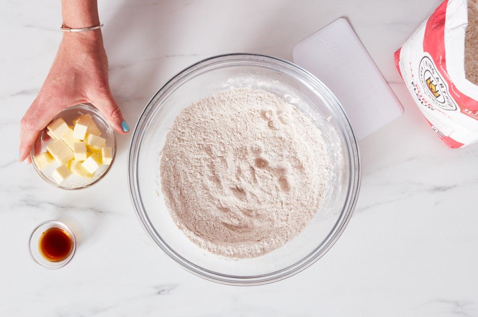 Bowl of flour next to bag of flour and small bowl of cubed butter