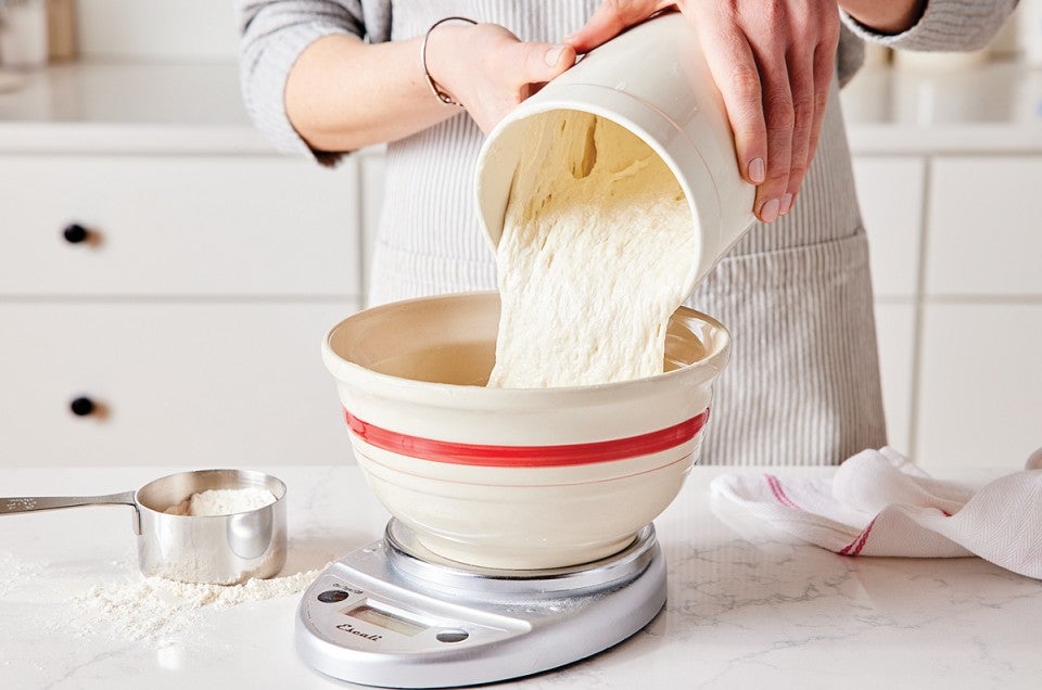 Baker pouring sourdough discard into bowl