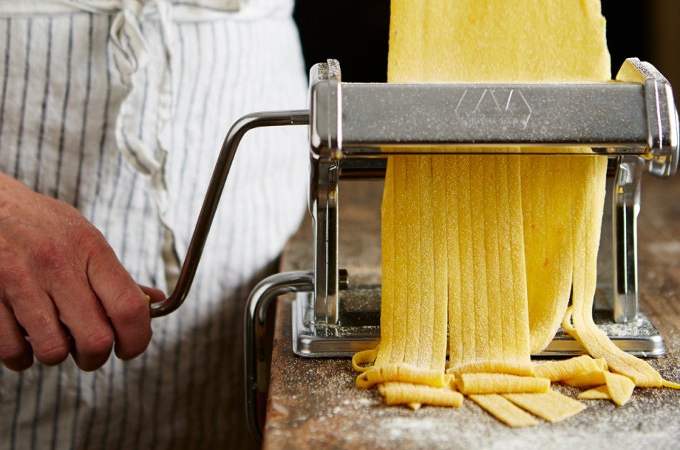 Pasta being cut through a pasta machine