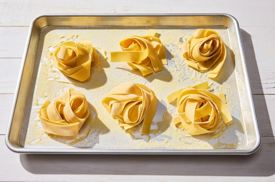 Nests of fresh pasta on a sheet pan