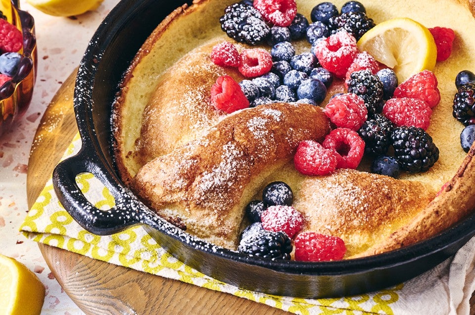 Lemon Puff Pancake with Fresh Berries in a cast iron pan - select to zoom