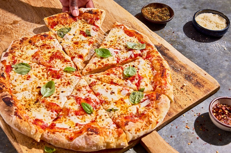 No-Knead Pizza Crust sliced on a cutting board - select to zoom