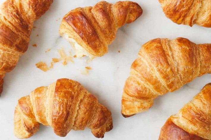 Croissant On Baking Sheet In Stainless Steel Oven Stock Photo