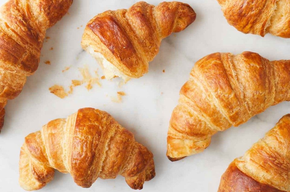 Croissant On Baking Sheet In Stainless Steel Oven Stock Photo