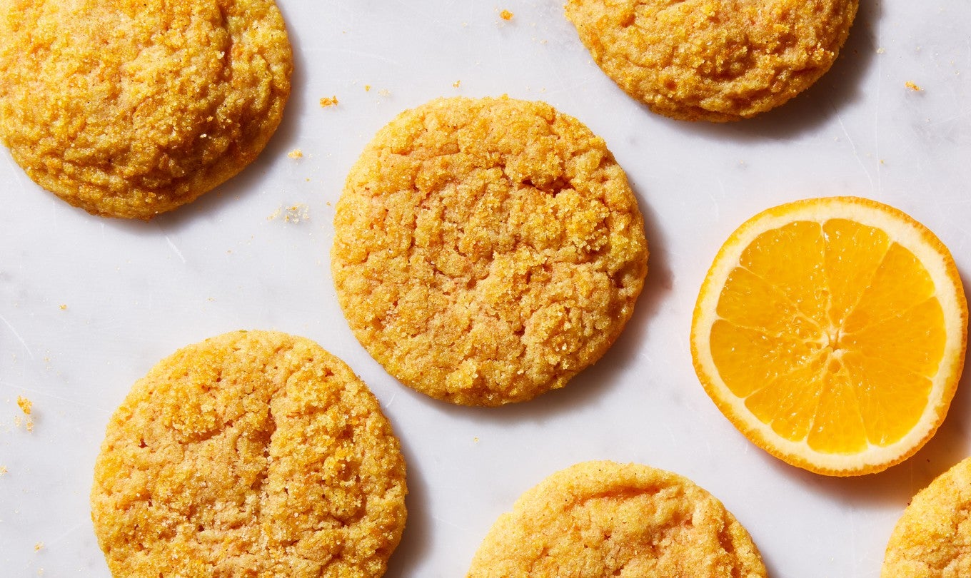 Olive Oil-Orange Sugar Cookies next to a few slices of orange