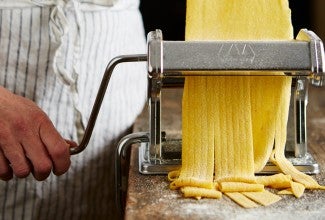 Pasta being cut through a pasta machine