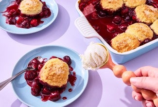 Buttermilk Biscuit Cherry Cobbler on a plate with ice cream being scooped