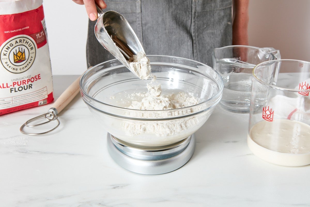 Adding flour to feed the sourdough starter