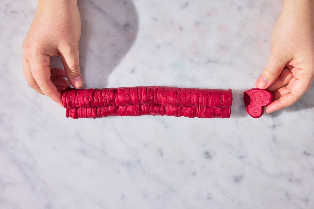 Assembling cut-out red hearts into a log 