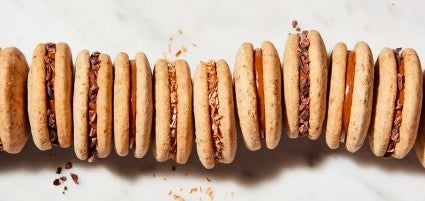 Cola de Mono Alfajores (dulce de leche sandwich cookies) lined up, coated in different garnishes