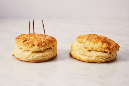 Flaky biscuit baked with toothpicks next to a flaky biscuit that has slumped over without toothpicks