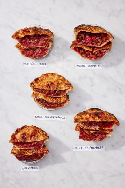 Five different mini strawberry-rhubarb pies sliced in half, all made with different pie thickener