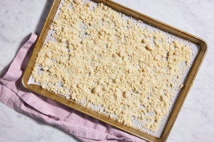 Parchment-lined baking sheet of cake crumbs