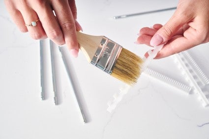 Using brush to clean parts of pasta maker