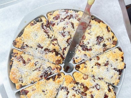 Using a tabl knife to separat baked scones in a scone pan prior to lifting them out of the pan.