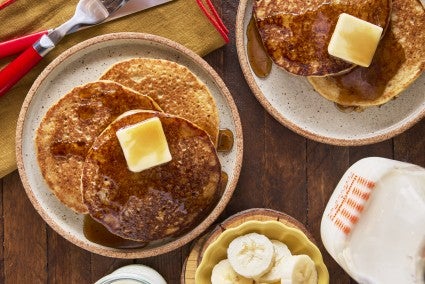 A stack of protein pancakes on a plate with butter and syrup