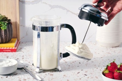 French press with plunger pulled out to show whipped cream made with the press