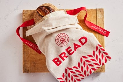 Reusable bread bag that holds a loaf of sourdough bread