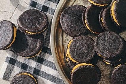 chocolate sandwich cookies with orange filling on a plate