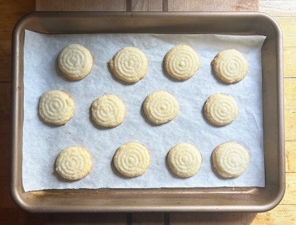 A dozen sugar cookies baked on a quarter sheet pan.