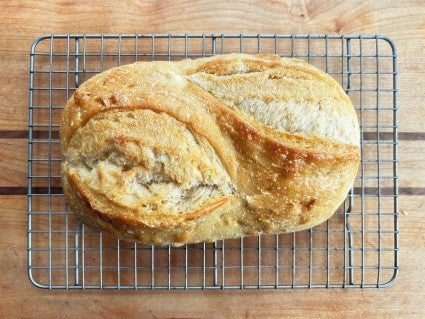 Oval sourdough bread on a cooling rack.