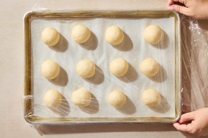 Unbaked, unrisen rolls in a baking sheet