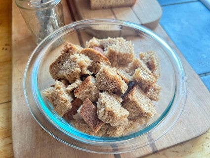 Vermont Whole Wheat Oatmeal Honey Bread torn into pieces and placed in a bowl to dry out.