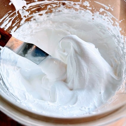 Beaten meringue in a bowl, ready to pipe and bake.