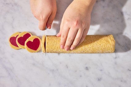 Slicing log of heart sugar cookies