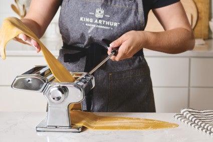 Rolling out pasta dough with pasta machine