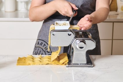 Rolling ravioli through a pasta machine