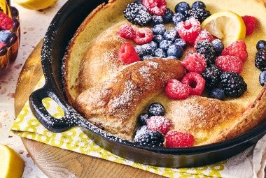 Lemon Puff Pancake with Fresh Berries in a cast iron pan